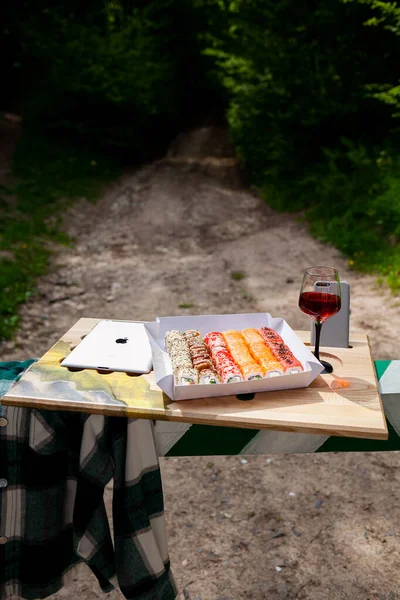 Lezzetli renkli suşi ruloları ve doğada bir bardak beyaz