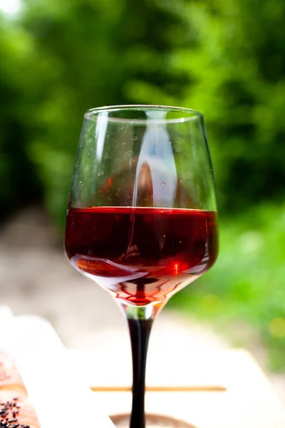 a large glass of red wine with splashes and bubbles. copy space, similar images