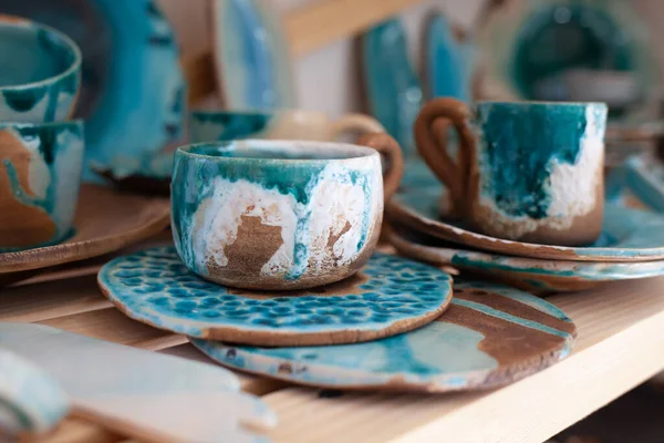 Pile de bols en céramique bleu à la main et la cuillère de bois sur une table en bois rustique contre le mur en bois peint bleu. — Photo