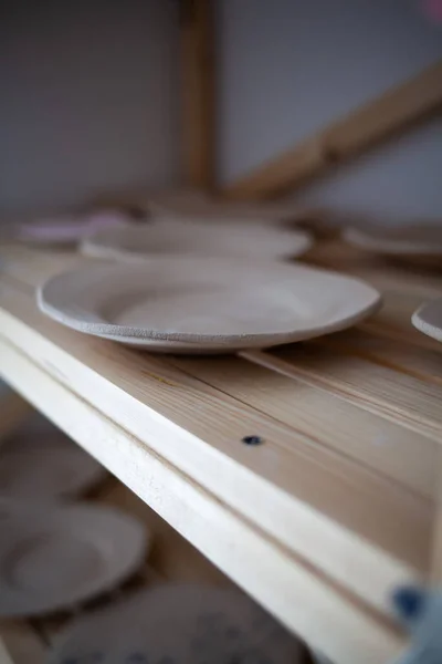 Pila di ciotole di ceramica blu fatto a mano e cucchiaio di legno su tavola di legno rustica contro la parete in legno verniciata blu. — Foto Stock