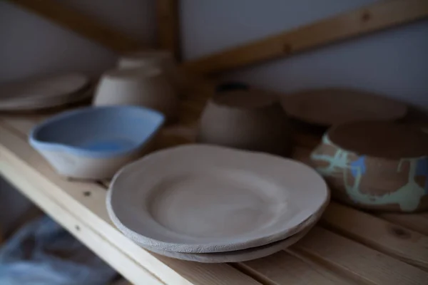 Стек ручной синий керамические чаши и деревянной ложкой на деревенский деревянный столик против синий окрашенные деревянные стены. — стоковое фото