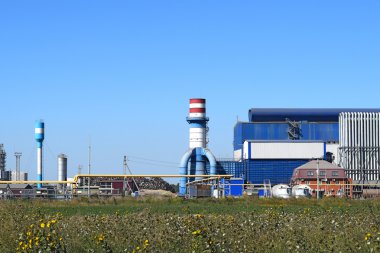 Hurda metal işlemek için büyük bir tesis. Büyük fabrika eski metal rafinerisi. Fabrika binasının mavi çatısı. Egzoz boruları, radyatörler, soğutma endüstrisi ve ofis binaları..