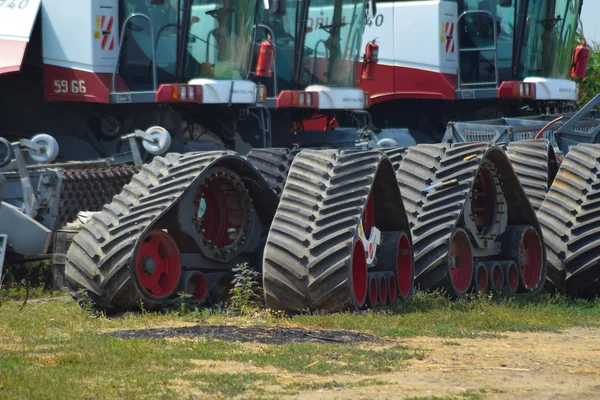 Las orugas de goma combinan cosechadoras. Estacionamiento de maquinaria agrícola . — Foto de Stock