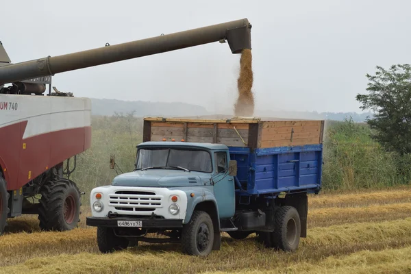 Unloading grain from a combine into a truck.