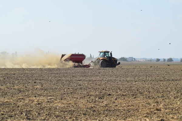 Traktor jedzie na polu i sprawia, że nawóz do gleby. Nawozy po orze pole. — Zdjęcie stockowe