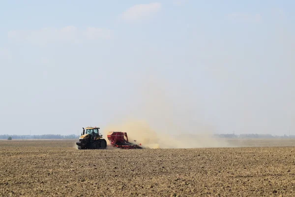 Trattore cavalca sul campo e rende il fertilizzante nel terreno. Fertilizzanti dopo l'aratura del campo . — Foto Stock