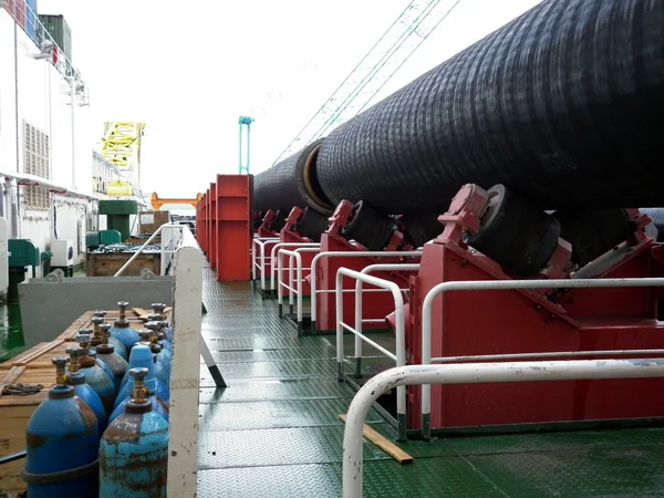 Deck pipe-laying vessel. pipes, valves and other equipment on the deck.