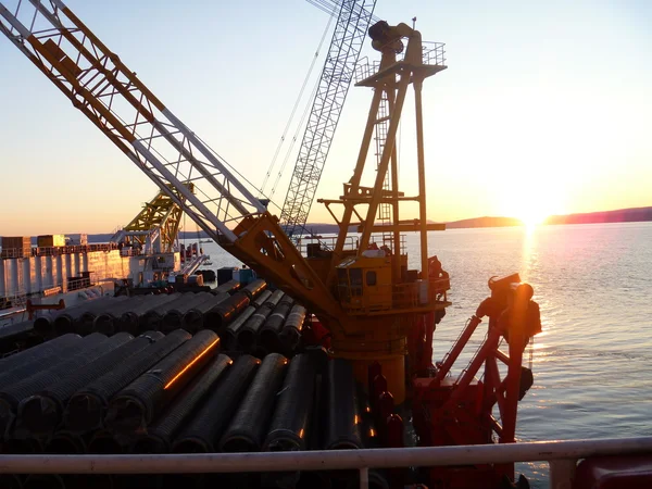 Deck pipe-laying vessel. pipes, valves and other equipment on the deck.