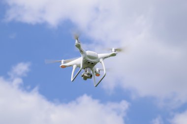Uçuş quadrocopters beyaz bulutlar ile mavi gökyüzüne karşı