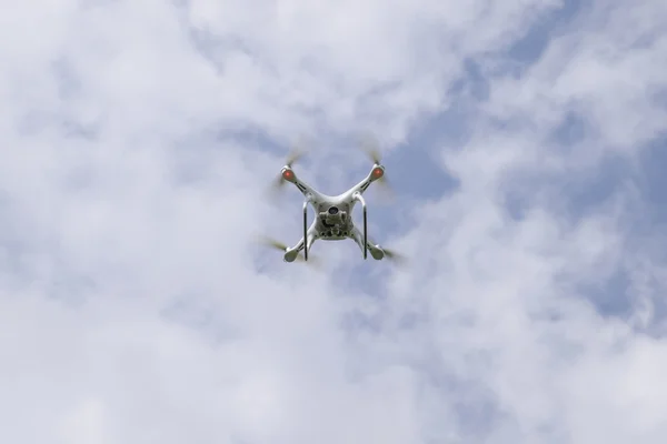 Vuelo quadrocopters blanco contra el cielo azul con nubes —  Fotos de Stock