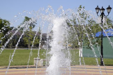 Parkta bir çeşme sıçraması. Çeşme güzel su jeti yayılan.