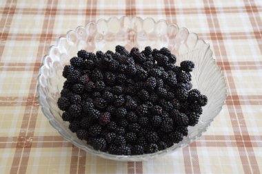 Meyveleri siyah böğürtlen ile plaka. Masada meyve çilek.