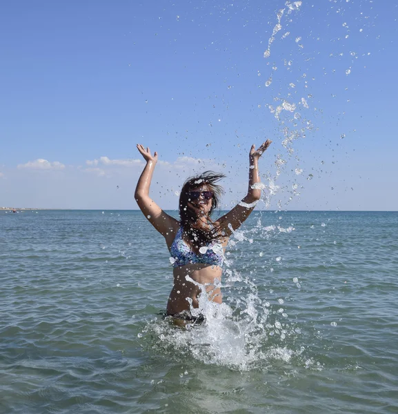 Она брызгает морской водой. — стоковое фото