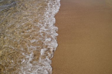 Kumlu sahilde alıştırma dalgalar. Deniz plaj.