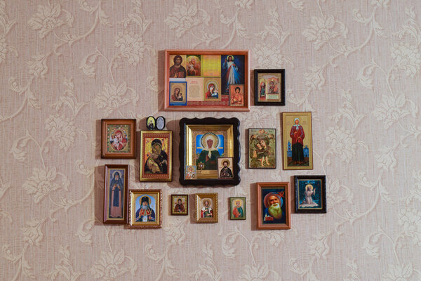 Россия, Полтавская деревня - 31 декабря 2015: Православные христианские иконы на стене, приклеенные обои
.