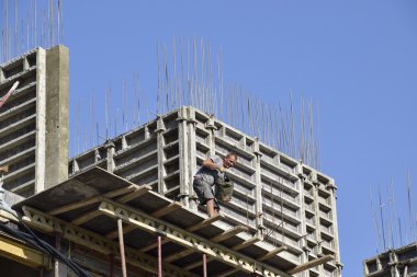 İşçi dökme çimento. Çok öykülü bir bina inşaatı. Binanın beton duvar montajı.