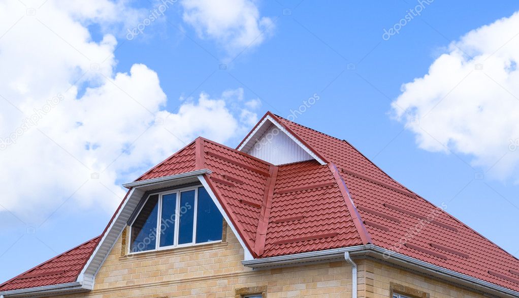 The house with plastic windows and a roof of corrugated sheet. Roofing of metal profile wavy shape on the house with plastic windows.