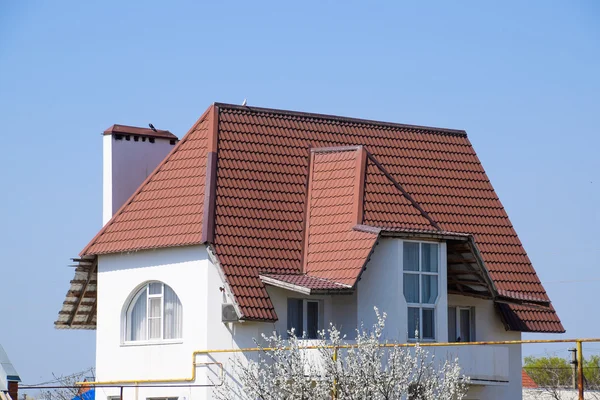 The roof of corrugated sheet on the houses. Individual homes with roof made of profiled sheet metal.