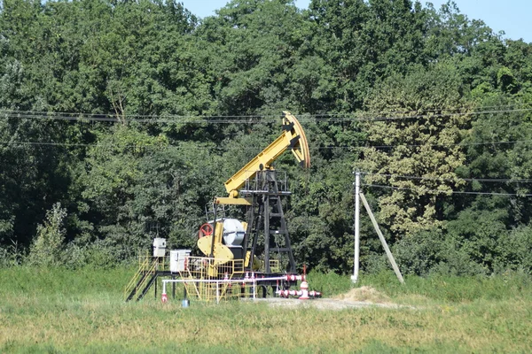 Насосная установка в виде нефтяного насоса, установленного на скважине — стоковое фото