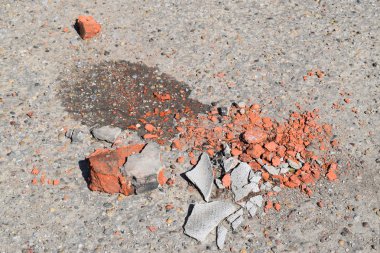Kırık tuğla ve kayrak asfalt üzerinde parçaları. İnşaat çöp.