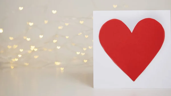 Red heart card on bokeh background with hearts. Valentine\'s day celebration or love concept. Copy space. Red and white