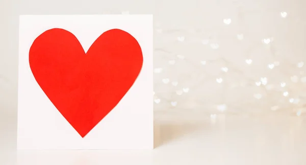 Red heart card on bokeh background with hearts. Valentine\'s day celebration or love concept. Copy space. Red and white