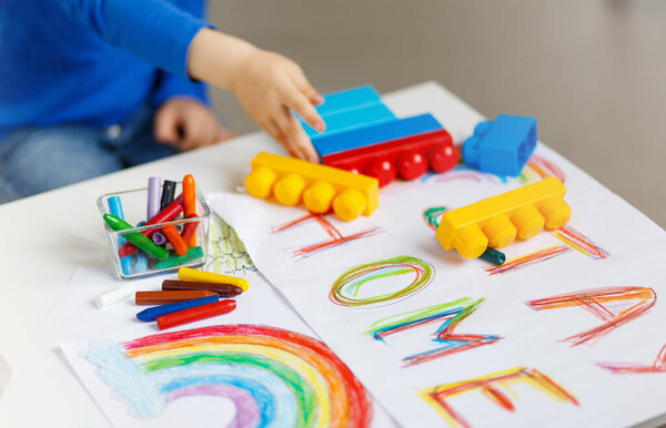 Kids paint. Quarantine fun. Child painting rainbow, sign of hope during coronavirus outbreak.School kid doing art homework. Arts and crafts for kids. Constraction