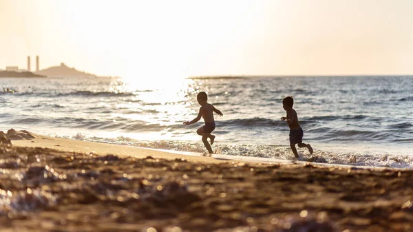 Силуэт Маленьких Мальчиков Играющих Пляже Закате Красивый Боке Песке Счастье — стоковое фото