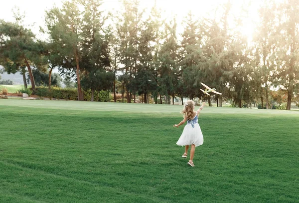 Kleines Mädchen Kleid Schießt Park Ein Spielzeugflugzeug Die Luft Kind — Stockfoto