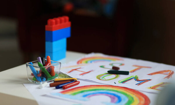 A boy of 4-7 years old sits at the table and draws with multi-colored paints. Childrens creativity. Childrens hobbies.
