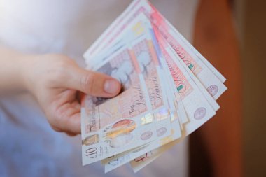 Yeni Plastik 10 ve 20 sterlinlik banknot kadınların elinde. Kriz ve tasarruf kavramı. İngiliz finans