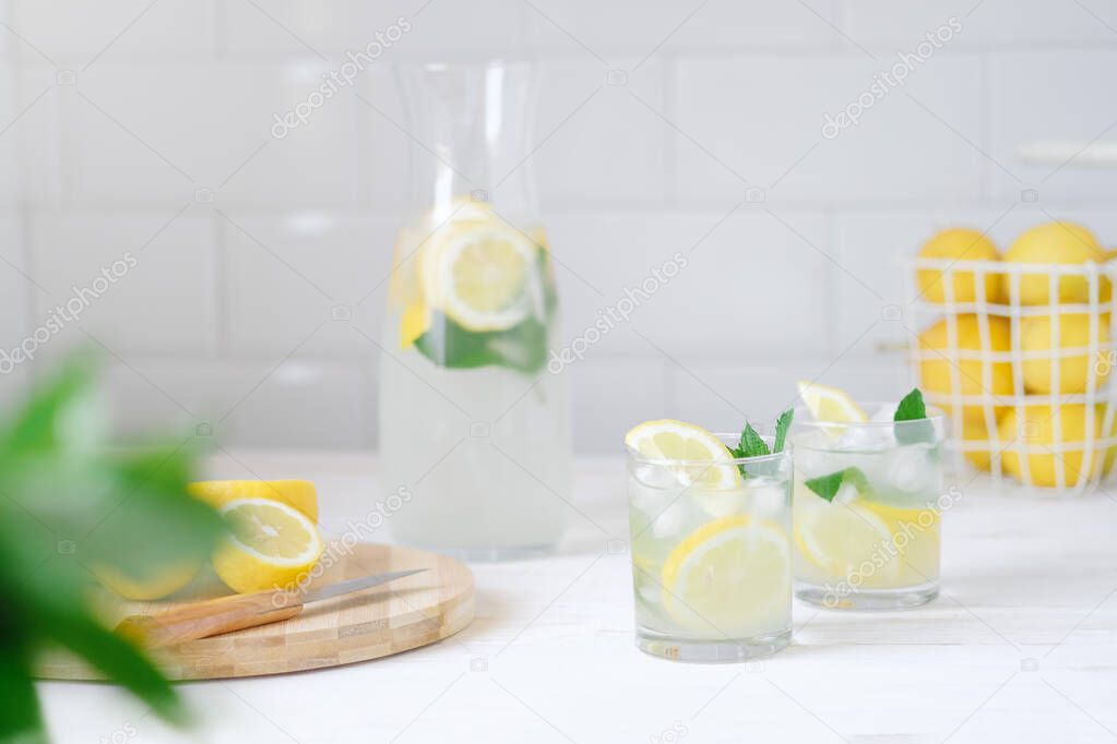 Fresh lemon lemonade with mint in bottle on kitchen table with ingredients. healthy nutrition diet concept. White background