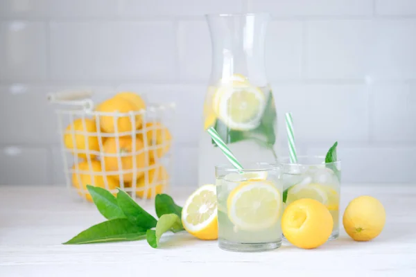 Limonada de limão fresca com hortelã em garrafa na mesa da cozinha com ingredientes. conceito de dieta nutricional saudável. Fundo branco — Fotografia de Stock