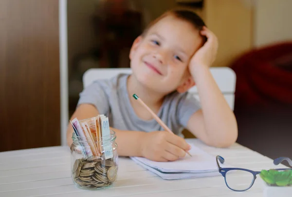 Kid Save money and dreaming about new toys, making a wish list, account banking for finance concept. Turkish lira coins in glass jar and banknotes