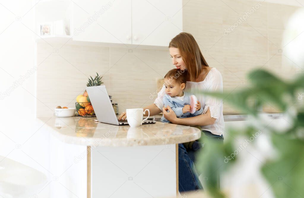 young woman with baby using laptop . Blogger, writer, journalist, student girl working on computer at home. Businesswoman, work from home, distance education, online learning, studying concept.
