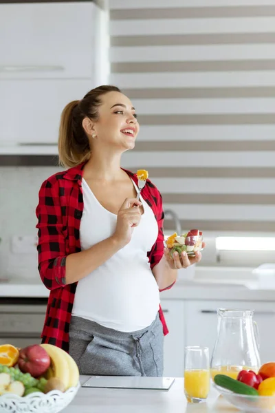 Attraktiv lächelnde Schwangere mit einer Schüssel Salat in der Küche — Stockfoto