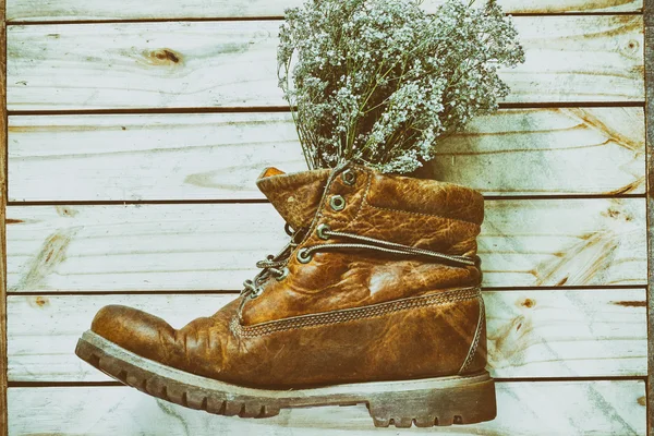 Old boots with dry wild flowers -applied vintage style processin — Stock Photo, Image