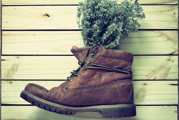 Flores secas en botas sobre fondo de madera estilo vintage .effcet —  Fotos de Stock