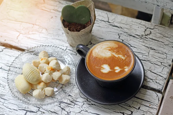 Кофейная чашка капучино и тайское печенье с отражением из окна — стоковое фото