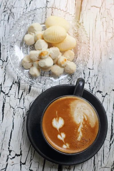 Cangkir kopi cappuccino dan kue Thailand dengan refleksi dari jendela — Stok Foto