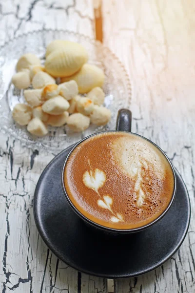 Coffee cup of cappuccino and Thai cookie with reflection from window — Stock Photo, Image