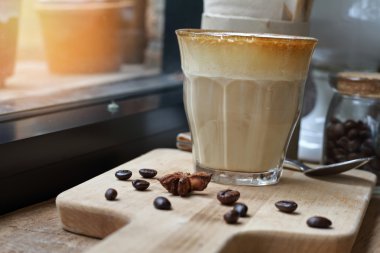 Kahve fincan kapuçino ve kahve çekirdeği ahşap masa .effect vintage tarzı görüntü ve gürültü