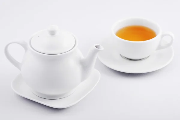 white tea cup with green tea and white teapot on white backgroun