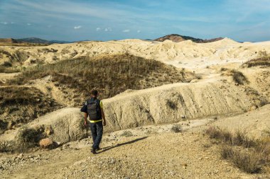 Sırt çantalı bir turist Romanya 'da çamur volkanlarını keşfediyor.