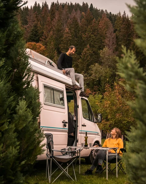 Young couple enjoying holidays in a camper van, that bring the following advantages: ease of social distancing, connection with nature and digital detox. Picture taken in Romania.