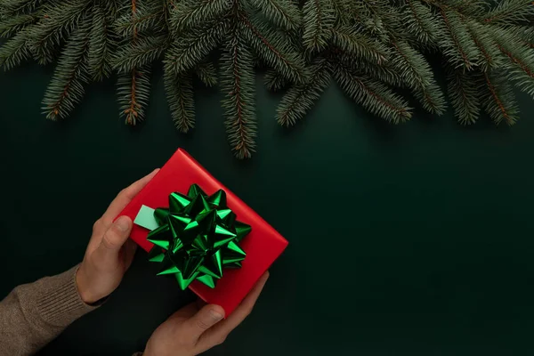 Adamın elinde güzel paketlenmiş bir Noel hediyesi var.