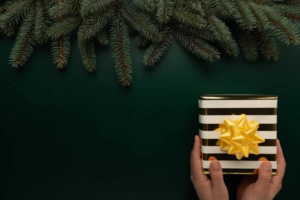 Adamın elinde güzel paketlenmiş bir Noel hediyesi var.