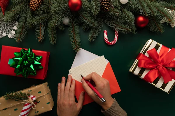 Bir adam Noel Baba 'ya Noel dilekleri ile bir mektup yazar. Yeni yıl dekoruyla süslenmiş bir masa..