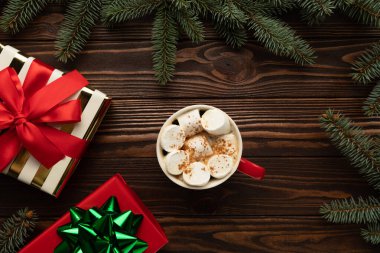 Noel süsüsüyle süslenmiş bir masada bir fincan kremalı sıcak çikolata var..
