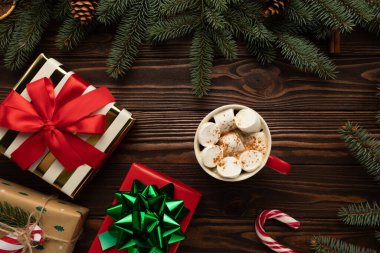 Noel süsüsüyle süslenmiş bir masada bir fincan kremalı sıcak çikolata var..